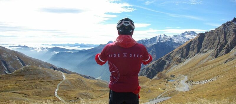 A cyclist is seen from behind as they look our across an extensive valley.