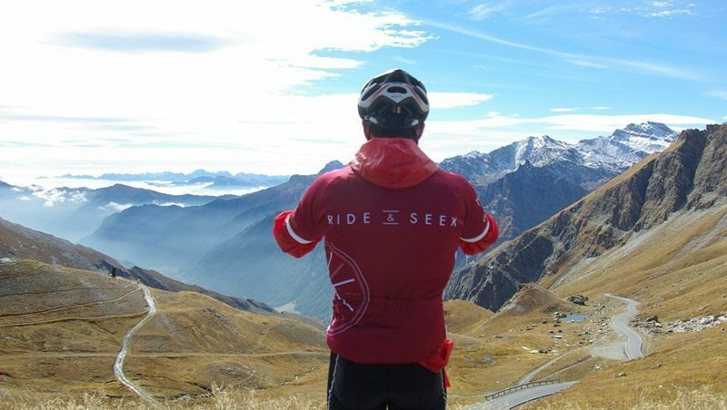 A cyclist is seen from behind as they look our across an extensive valley.