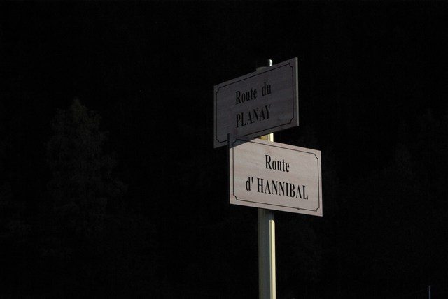 A signpost illuminated against a black sky.