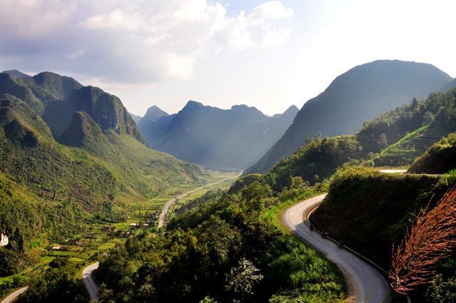 Scenic photo in Vietnam. A road winds along the side of a hill beside a valley.