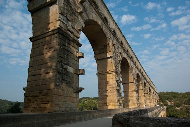 A tall Roman bridge with supporting arches from below.