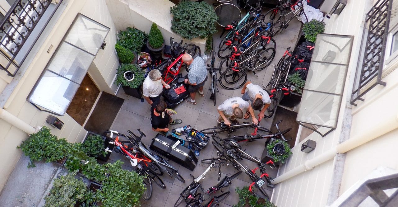 Overhead photo of four people amongst a multitude of bikes in a small internal courtyard.