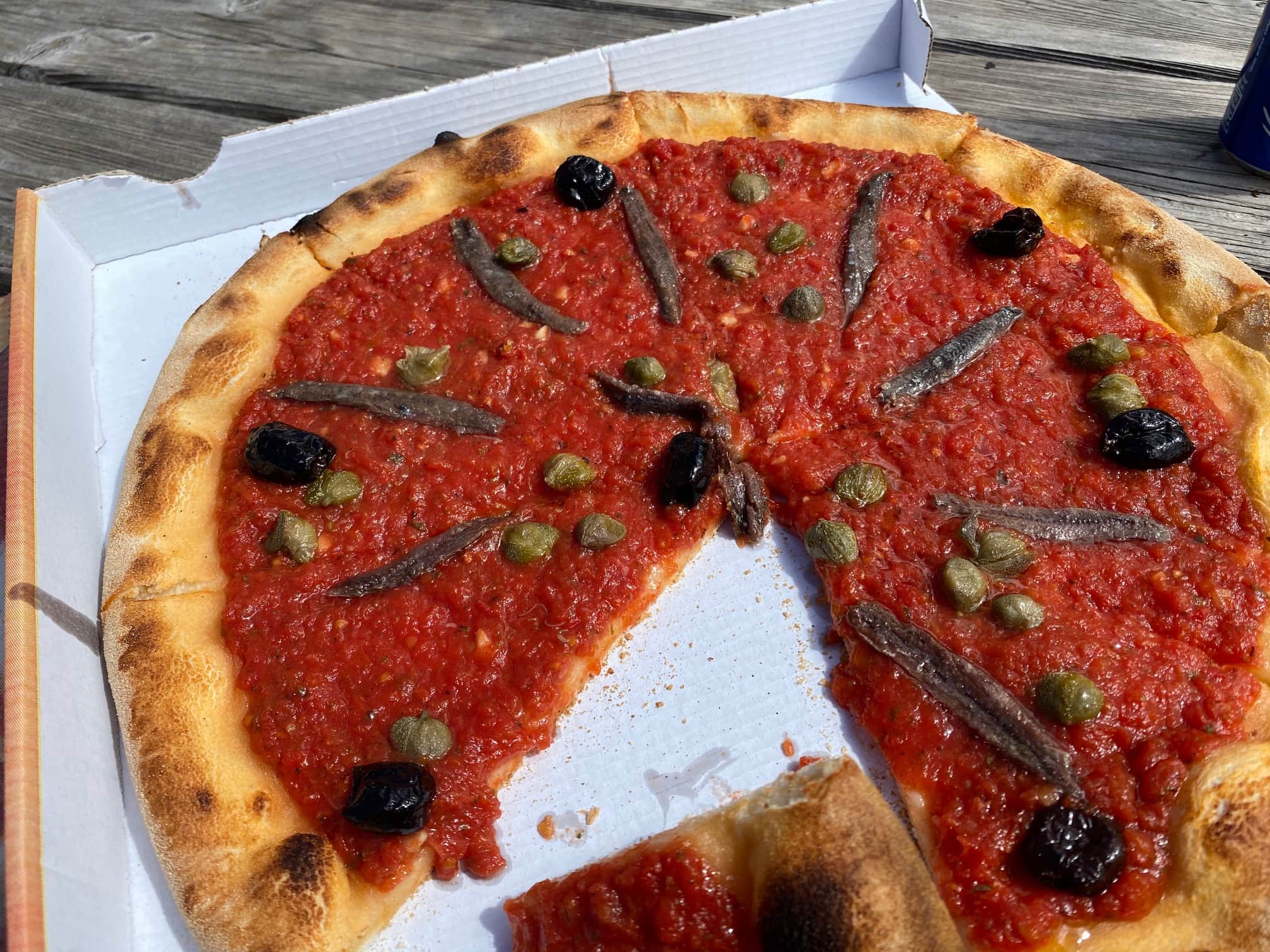 A pizza with a slice removed.