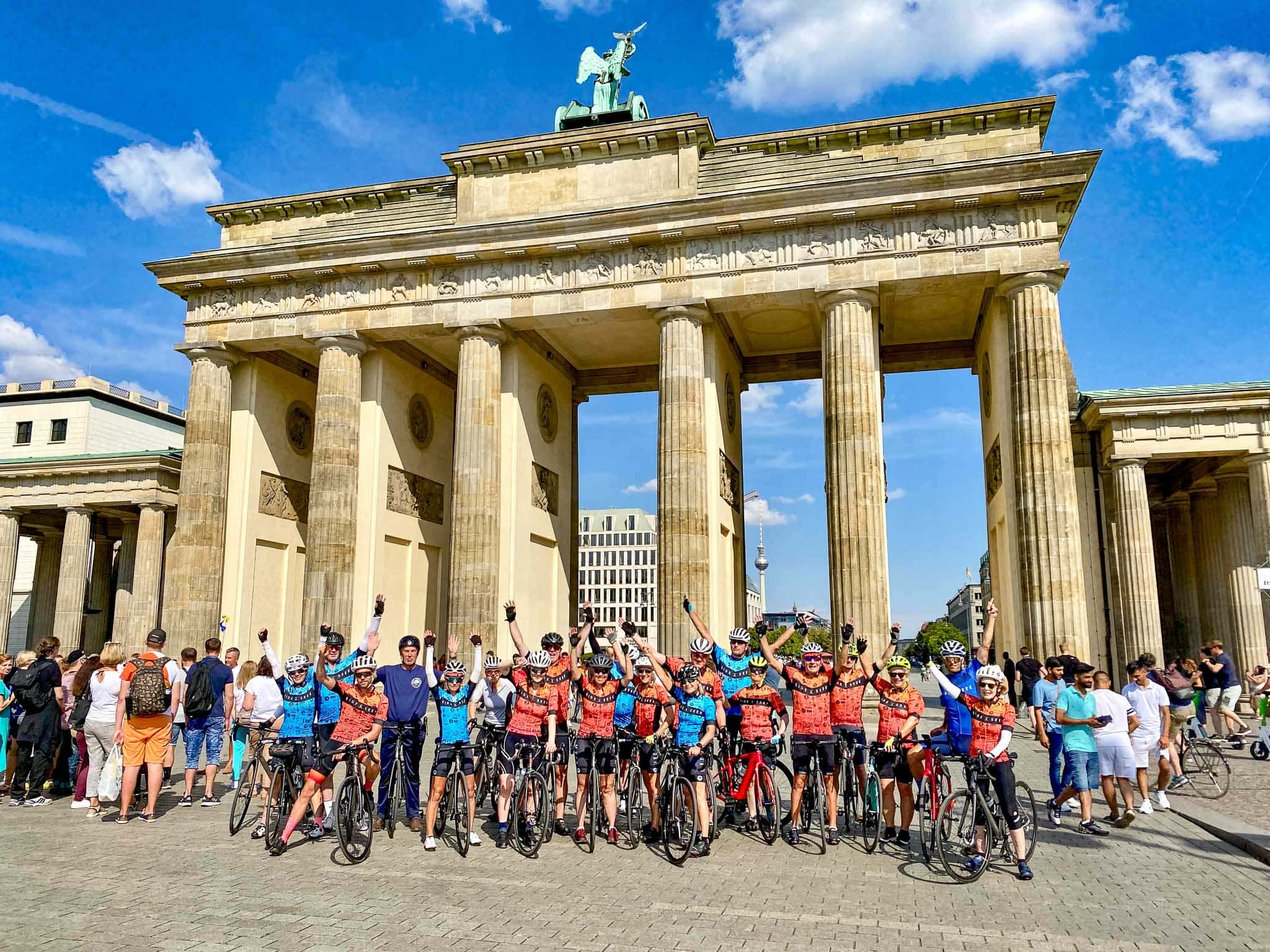 Group photo of cyclists and bikes infront of the Brandenburg Gate in Berlin