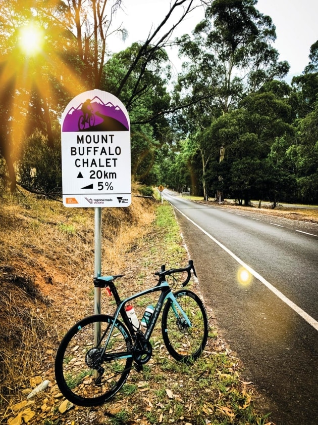 Road bike leaning against the Mount Buffalo challet gradient sign.