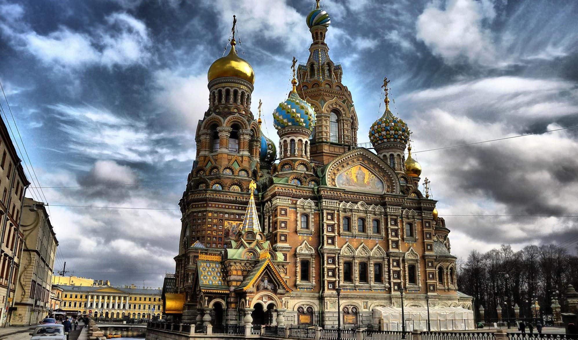 An impressive cathedral of Russian architecture stands tall against a grey, cloudy sky in the square of an old town.