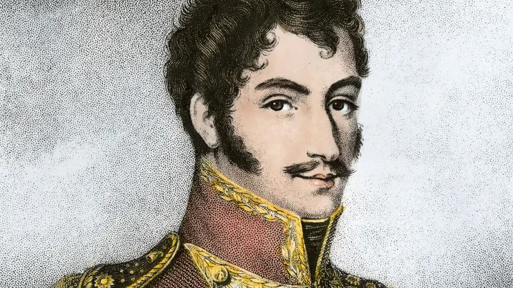 A formal portrait of a man in military uniform. The uniform he wears has a high red collar with a gold trim. The man has short, dark hair and moustache.