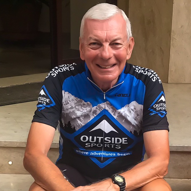 Jim Cox sits smiling at the camera in a cycling kit.