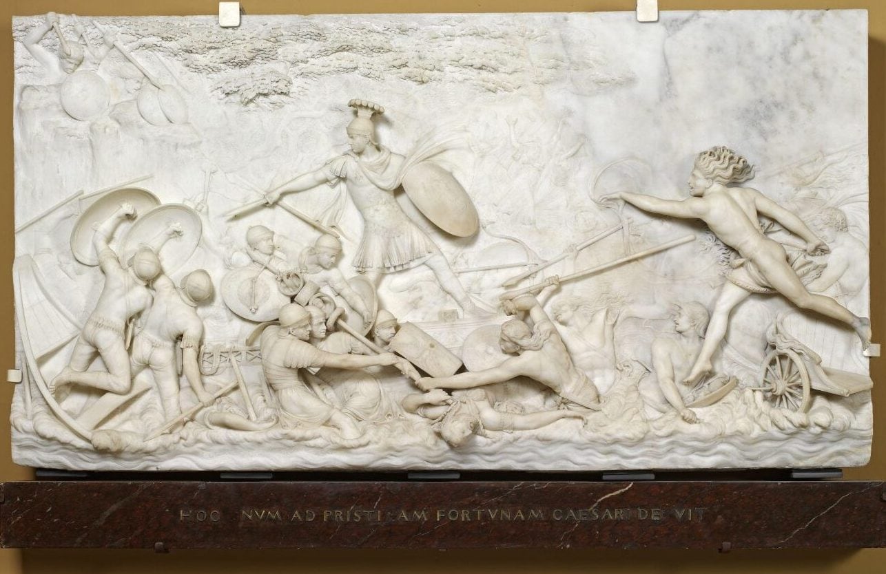 A Roman battle scene set in Britain sculptured into marble depicting Roman and English soldiers at battle. The Roman soldiers are victorious with their shields and spears.