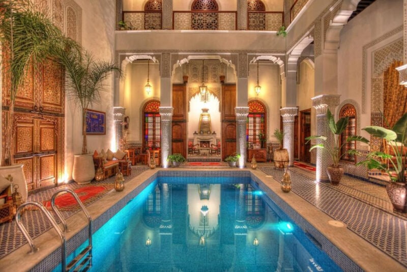Interior of a riad with a clear blue pool in the centre.