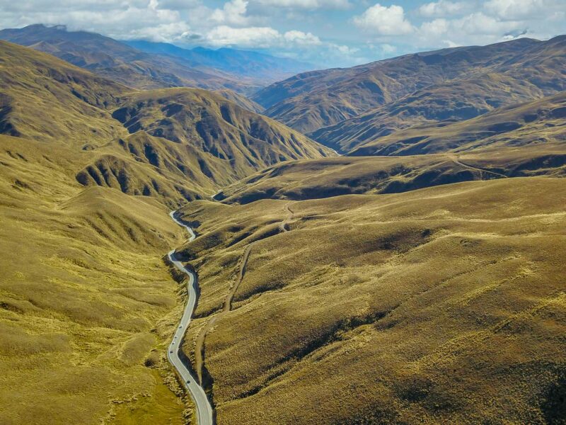 road running through treeless mountains on either side