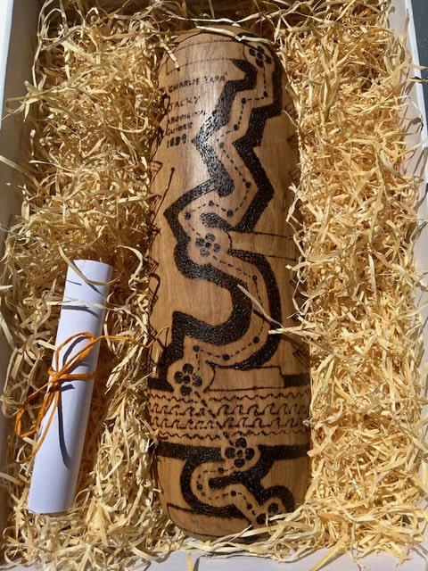 STRZ Message Stick A modern message stick with a map of the Ride and Seek Strzelecki Tour etched and burnt into a large, rectangular piece of Yellowbox wood that is slightly rounded.