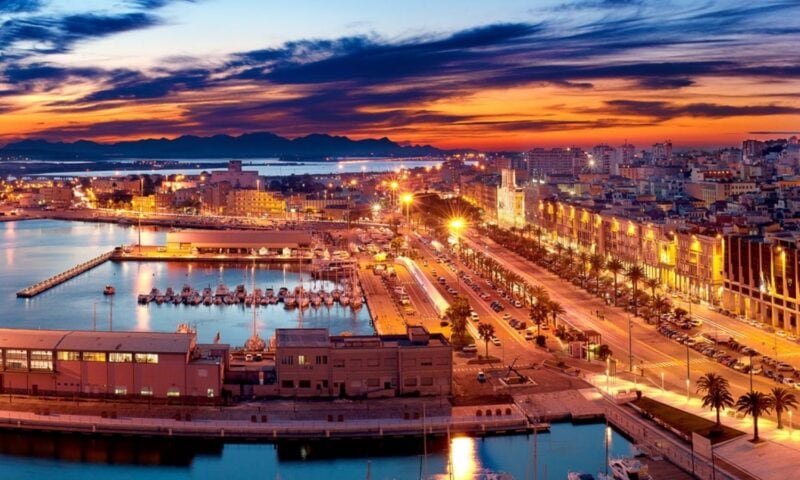 Photo of the old town and the harbour in front from above. The town is illuminate