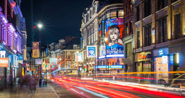 A city scene of West End at night. Illuminated, multi-story old buildings line the street.