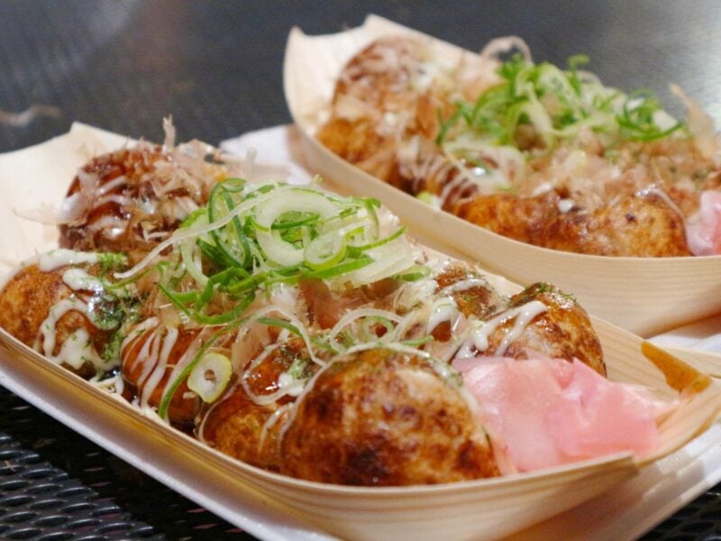 Plates of Japanese Street food, takoyaki octopus balls.
