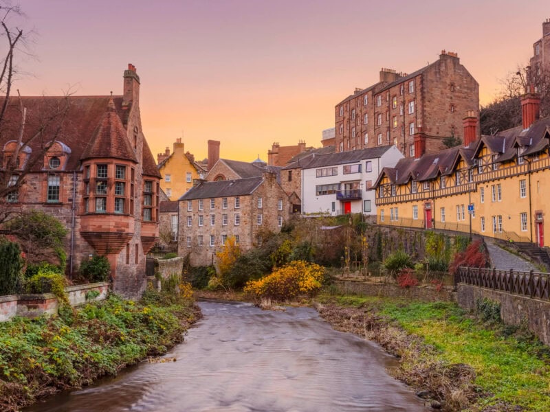 Peaceful riverside village with stone cottages, narrow lanes, and warm evening light.