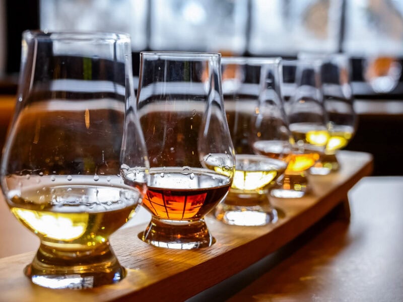 A selection of whiskey glasses arranged for a tasting session with warm lighting.