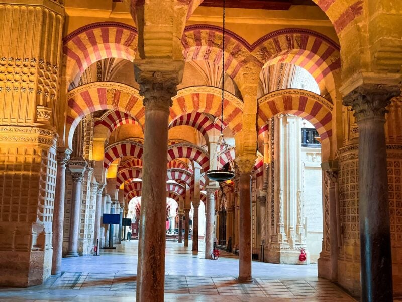 Interior of mosque with red and white arches in the Alhambra