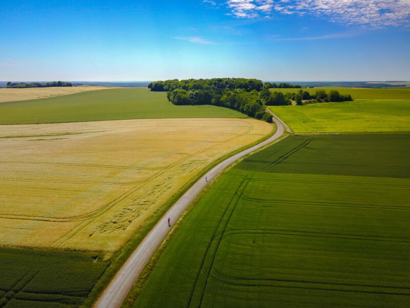 Aerial view of cyclists on rural farmland road