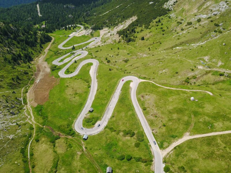 Aerial view of winding mountain road through green hills