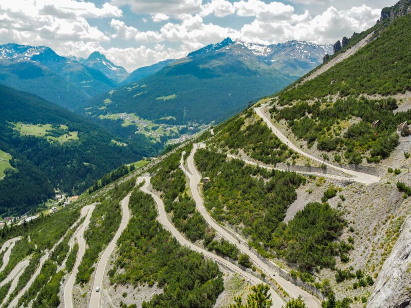 Winding mountain road overlooking lush alpine valley