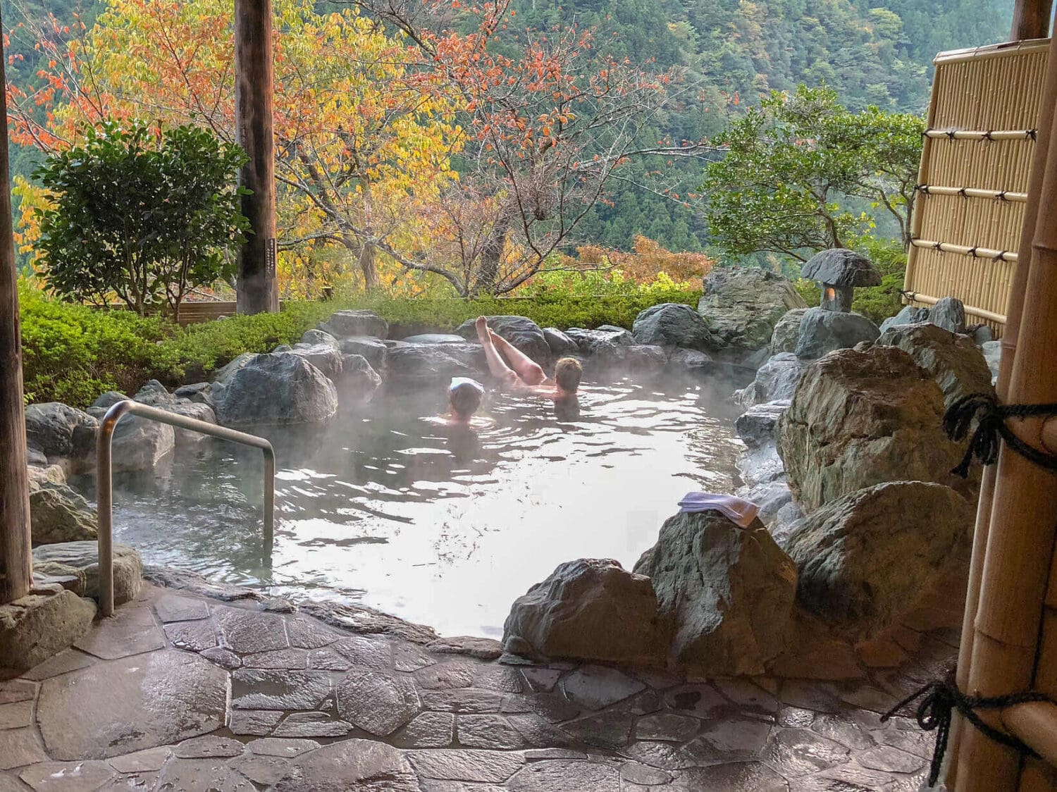 Japan cycling tour guests soaking in traditional Japanese onsen with fall colours