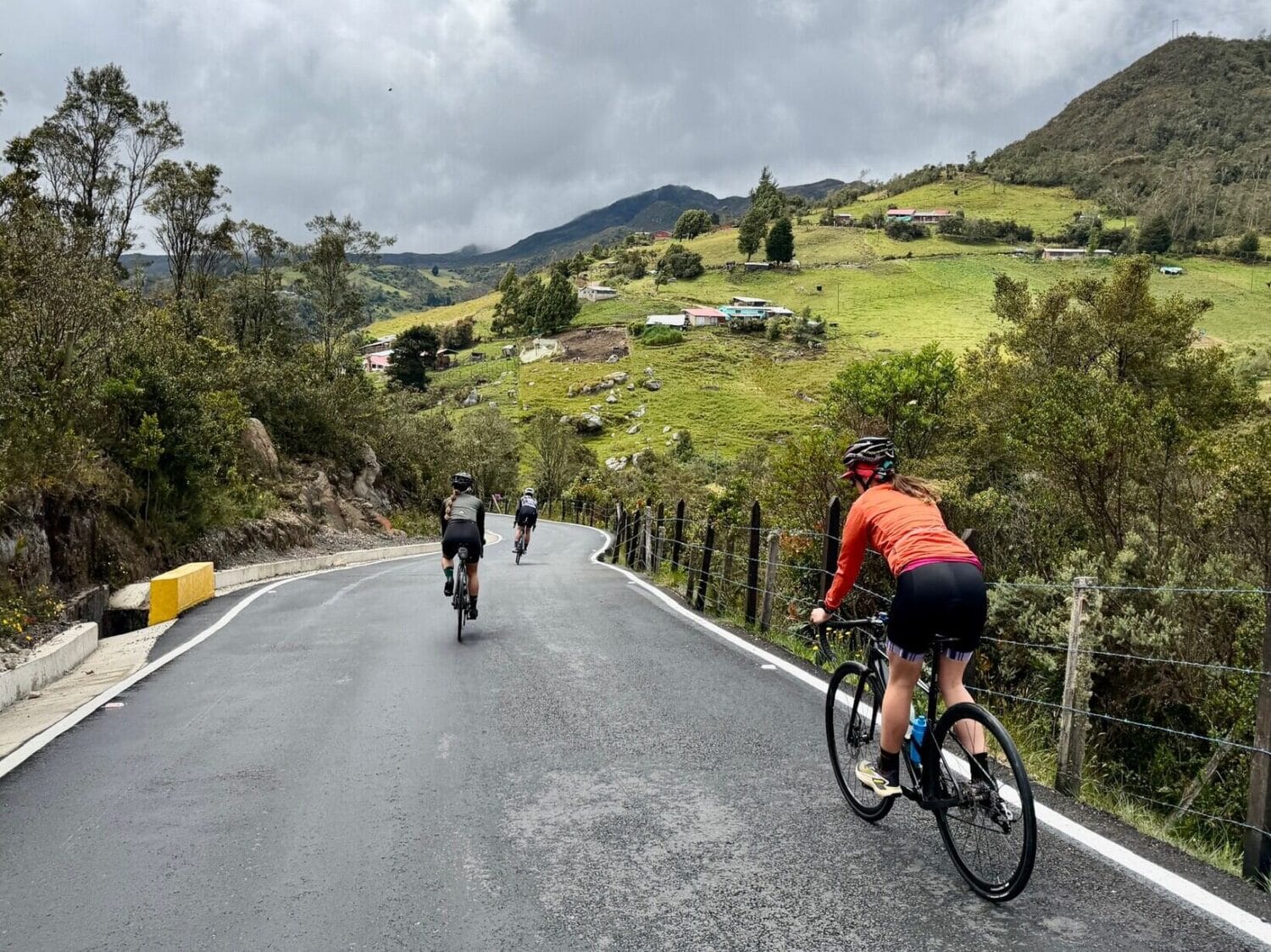 Cyclists riding through green Andean countryside on a mountain road, Colombia, on the Bolivar cycling tour