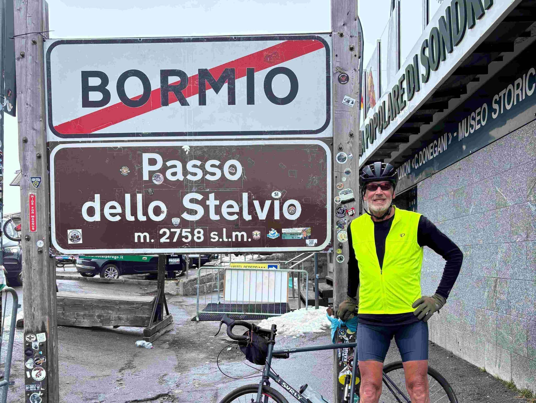 Paul standing with his bike at the Passo dello Stelvio sign on a Ride & Seek cycling tour.