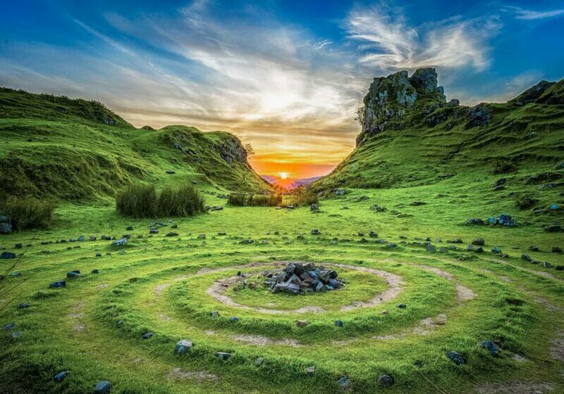 Celts Circle Stones Scotland A circular stone arrangement on a grassy hillside, surrounded by lush valleys, under a golden sunset sky.