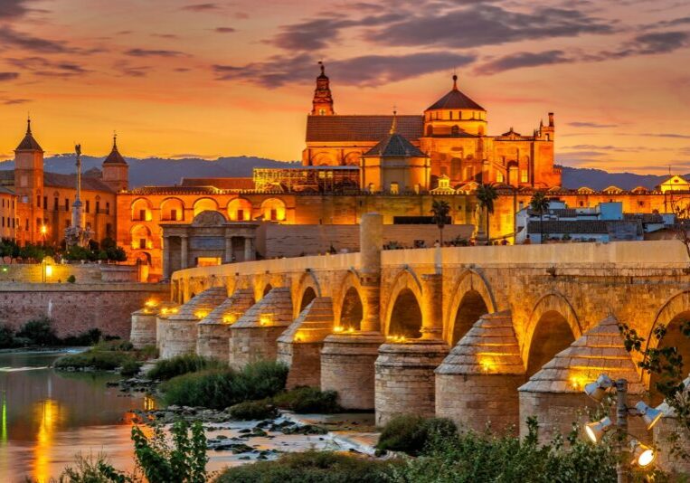 Cordoba At Sunset A golden sunset scene of Cordoba from across the rive with an old bridge in the foreground.